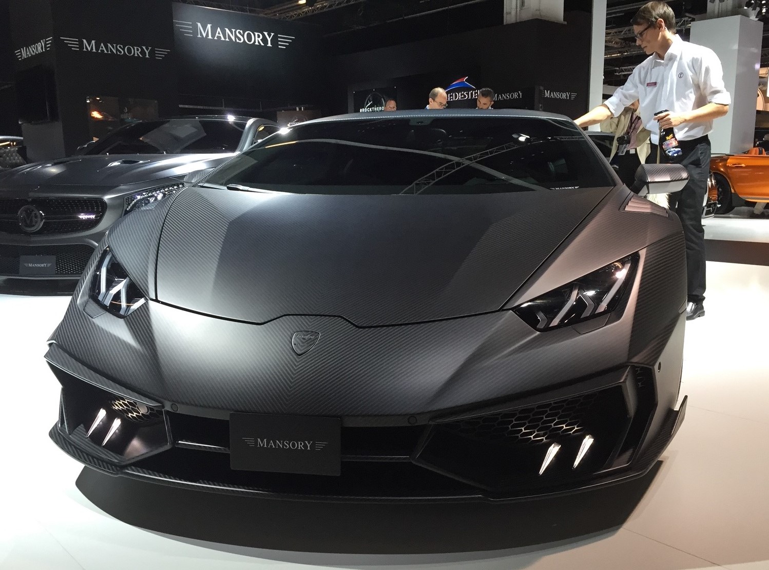 Ein dunkler Sportwagen auf einem Automobil-Messestand.