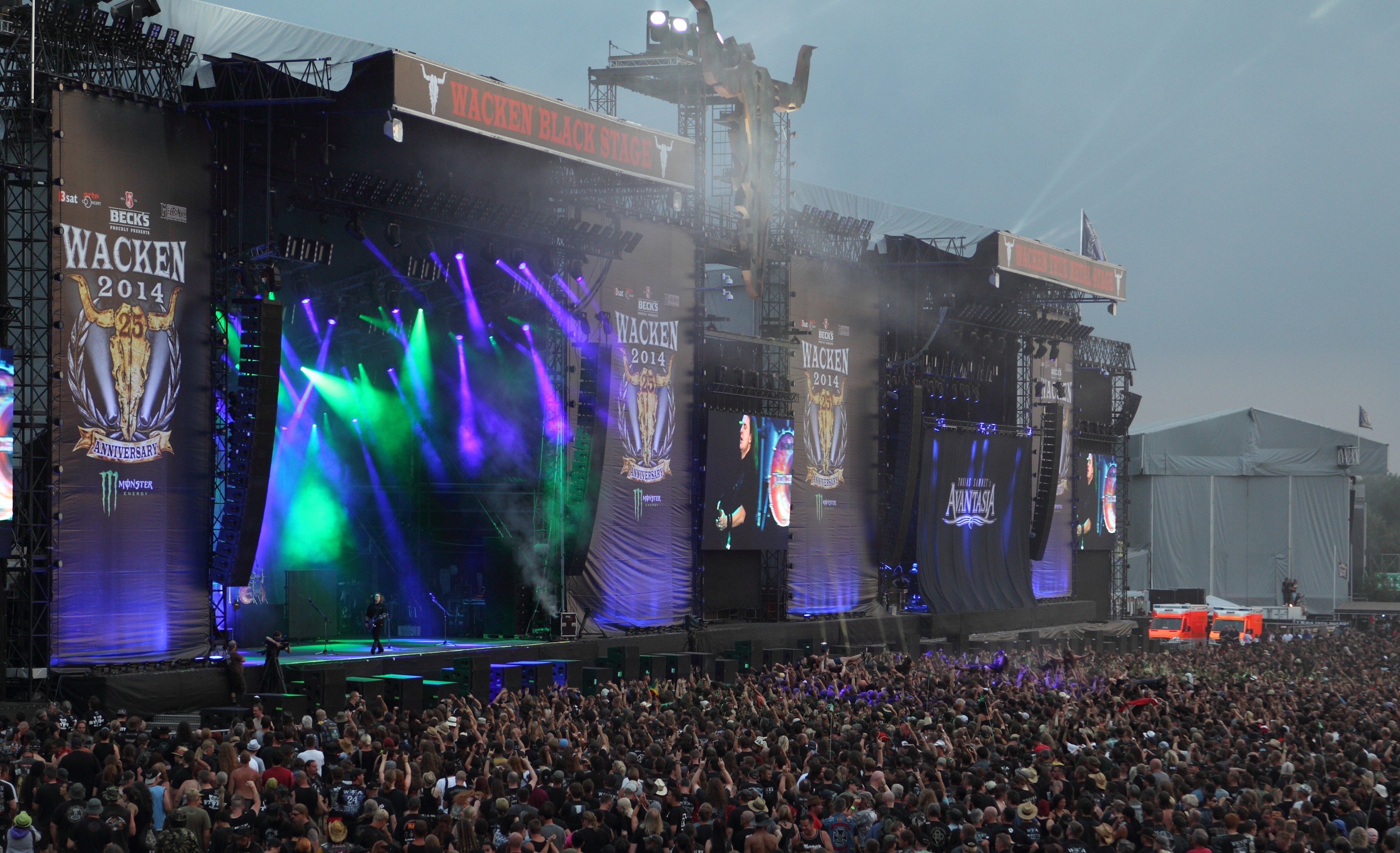 Große Festivalbühnen mit farbigem Licht und einem dicht besetzten Zuschauerbereich.